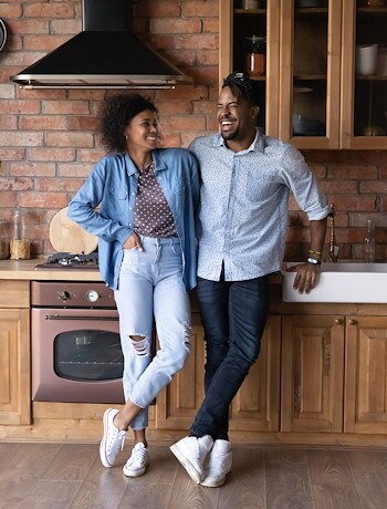Couple standing in their new home's kitchen
