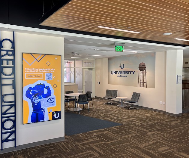 A photograph of a UCU and UC Davis branded office that contains seating and tables for consultations