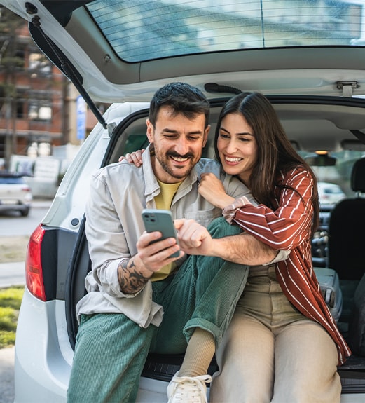 Couple sitting on the back of their car together