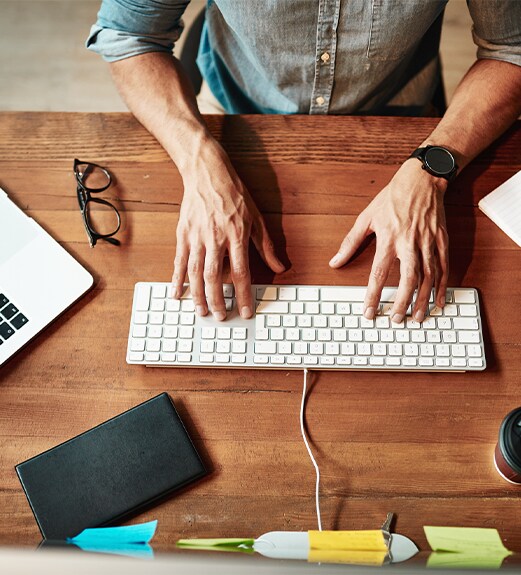 Close up view of hands at a computer desk keyboard