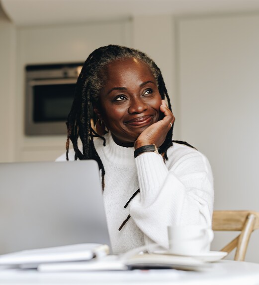 Happy woman looking up from doing tax work on her computer