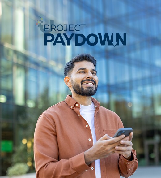 Smiling man looking up from his phone confidently outside