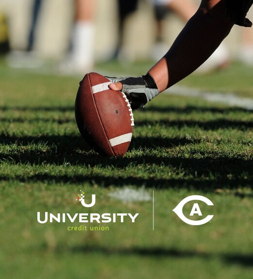 close up of a hand holding football out on the grass field