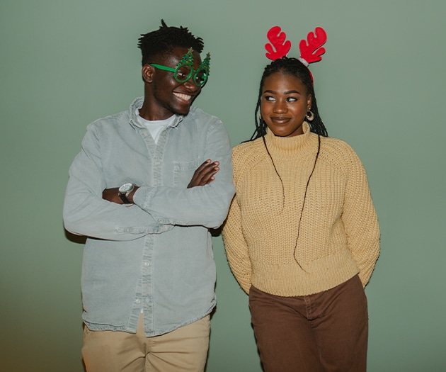 Young couple wearing festive gear at a holiday party