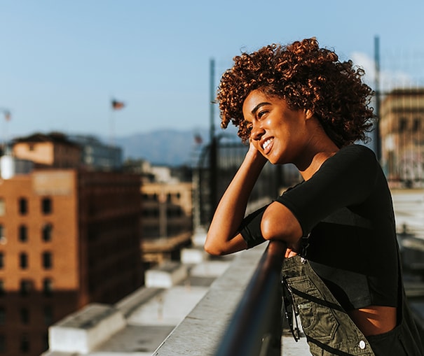 Woman looking out at the city from the top of a skyscraper