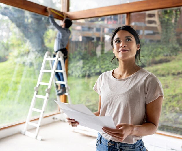 Young woman looking up from plans for a HELOC home improvement project
