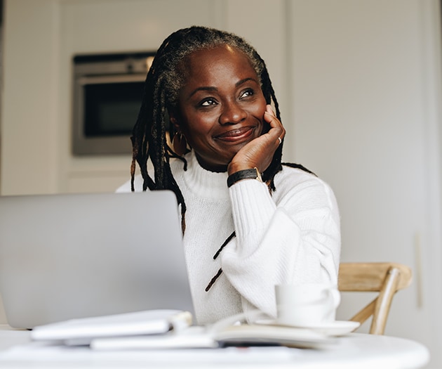 Happy woman looking up from doing tax work on her computer