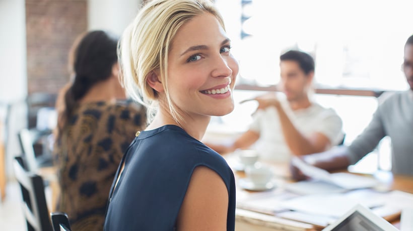 Smiling woman looking at camera after checking her bank account