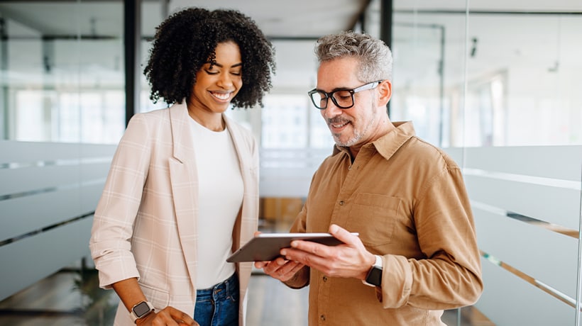 A man and woman looking at a tablet