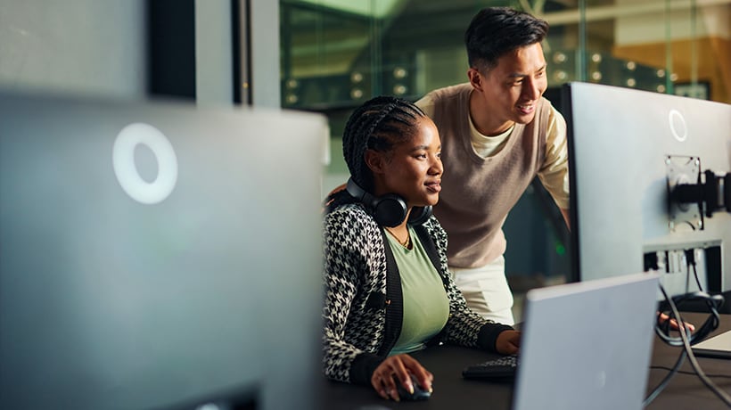 A man and woman looking at a computer screen