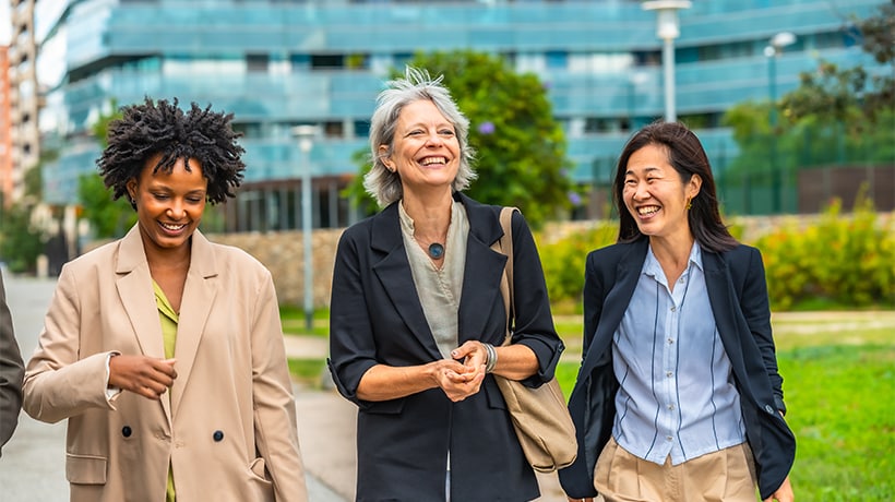 A group of university staff walking outside and smiling