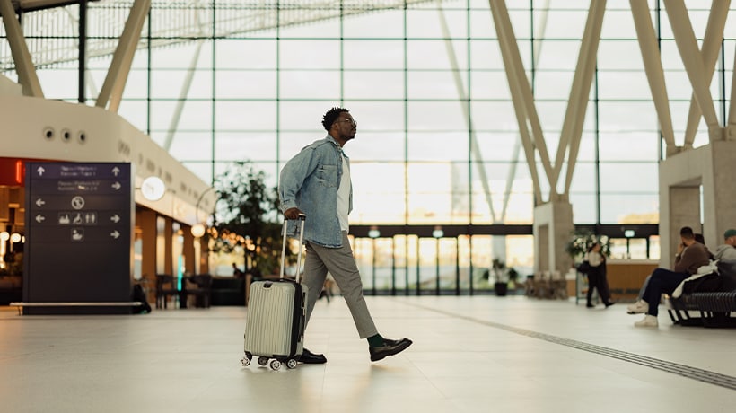 Man in the airport walking to his flight for summer travel.