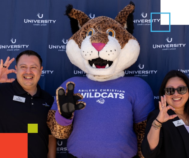 A man and woman standing beside the Wildcat mascot