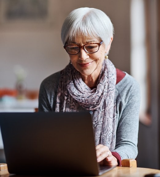 A woman reading financial tips, industry news, and more on a laptop