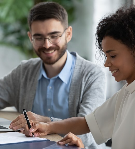 Happy couple completing a laon application in an office