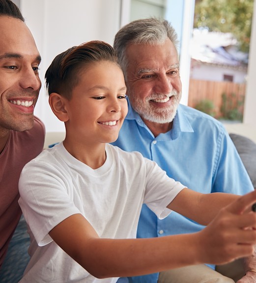 Young boy taking a selfie with his father and grandfather