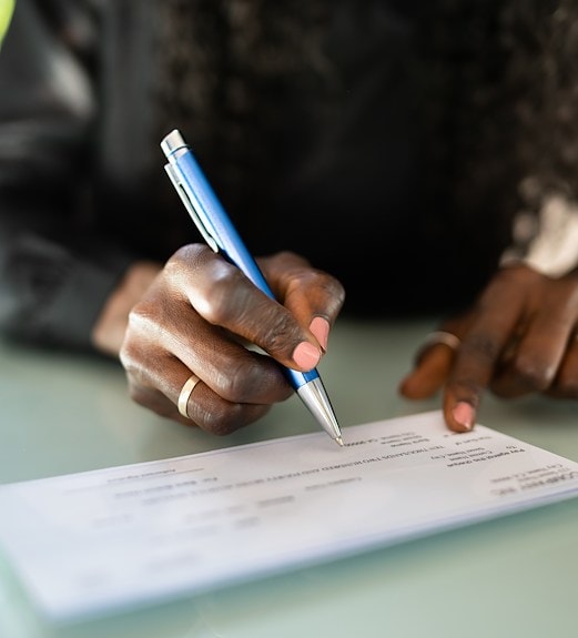Close up view of a person's hands signing a check