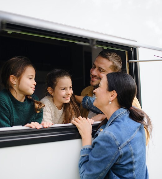 Mother and father having fun with their kids in a camper van