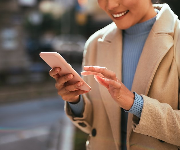 A woman tapping on the screen of a smart phone.