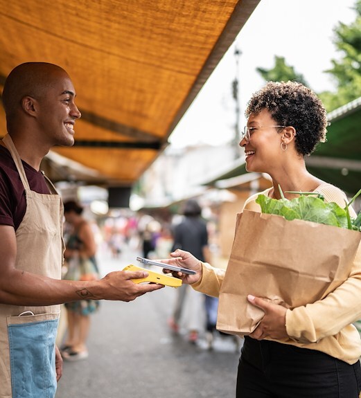 Woman using Google Pay to tap to pay for groceries