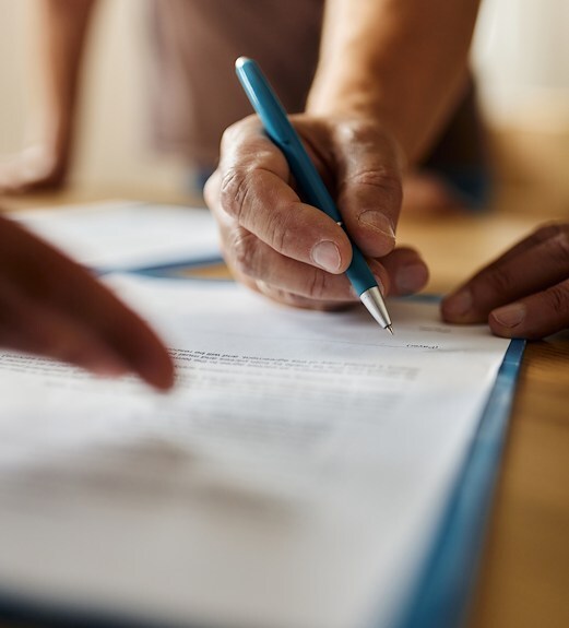 Close up view of a hand holding a pen filling out a form