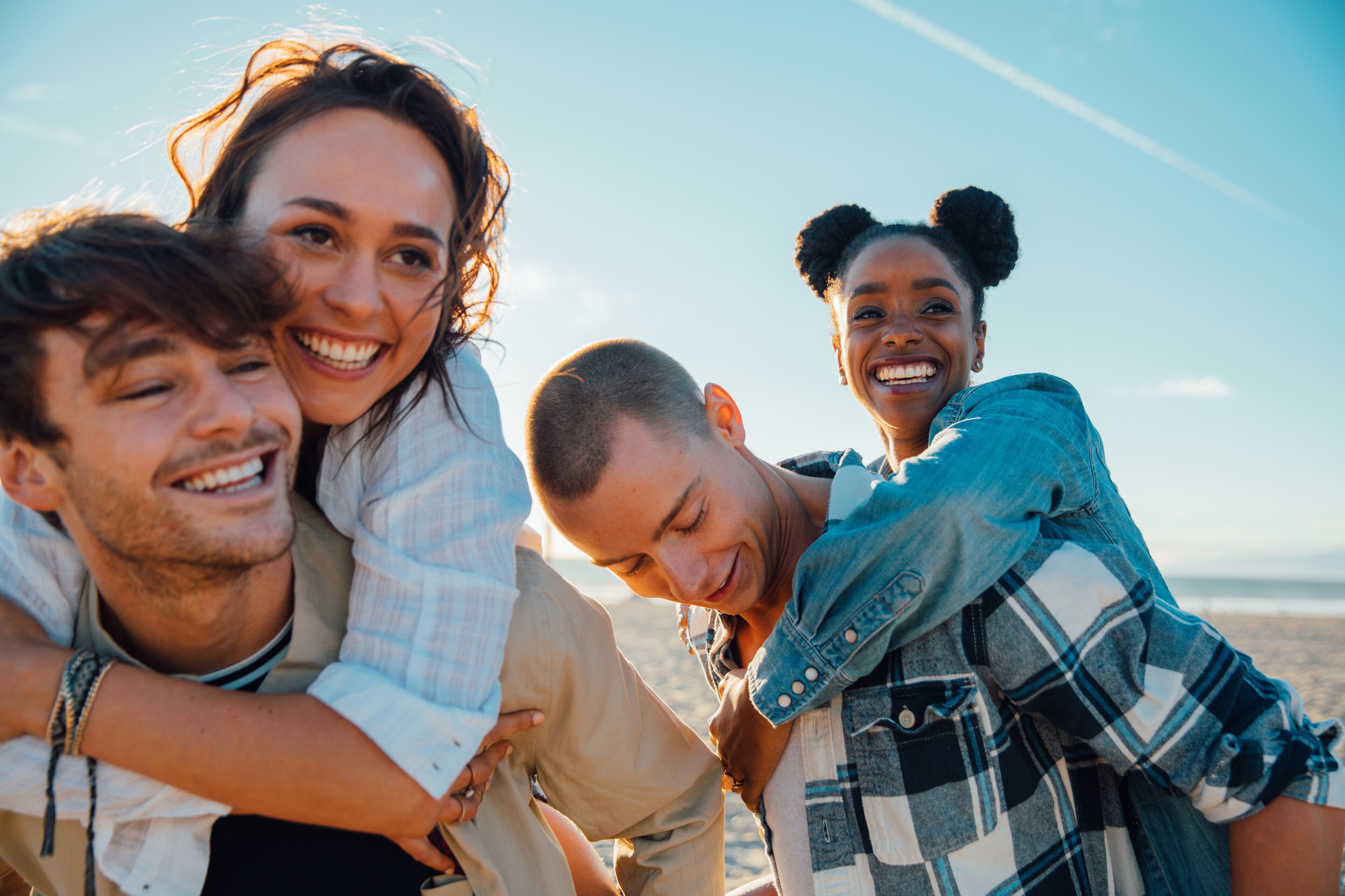 Happy group of friends exploring a sunny beach together