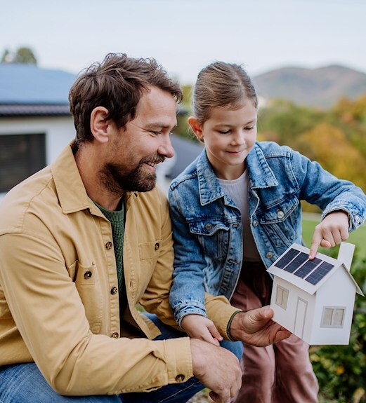 Father and daughter looking at a model house