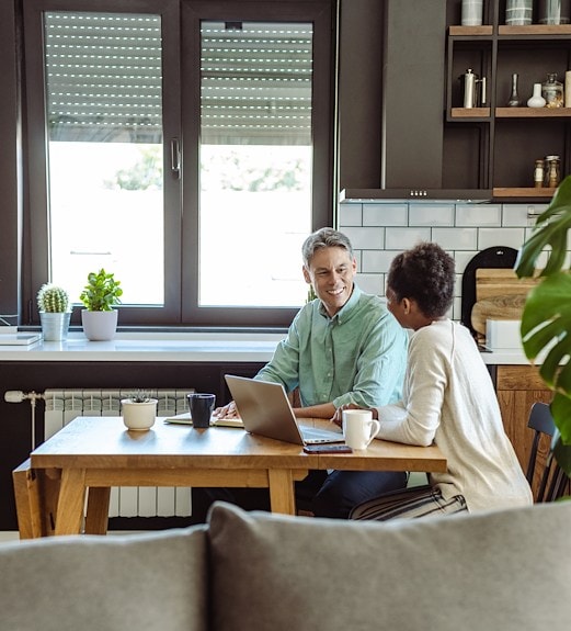 Middle aged couple reviewing loan options together at their kitchen table