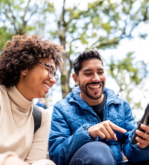 Two friends using pay a person on their phone to transfer funds