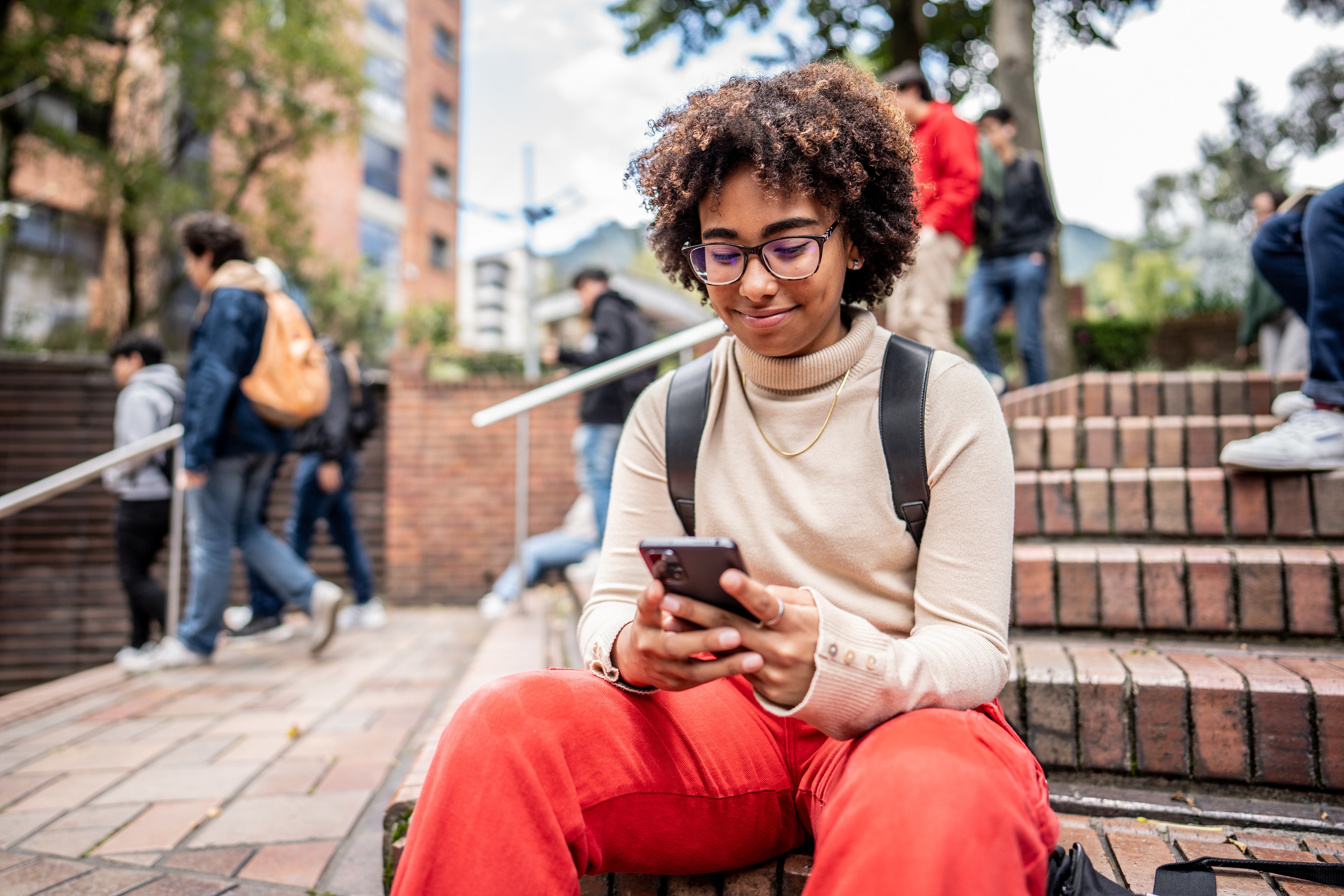 Young woman on a college campus checking her digital banking account