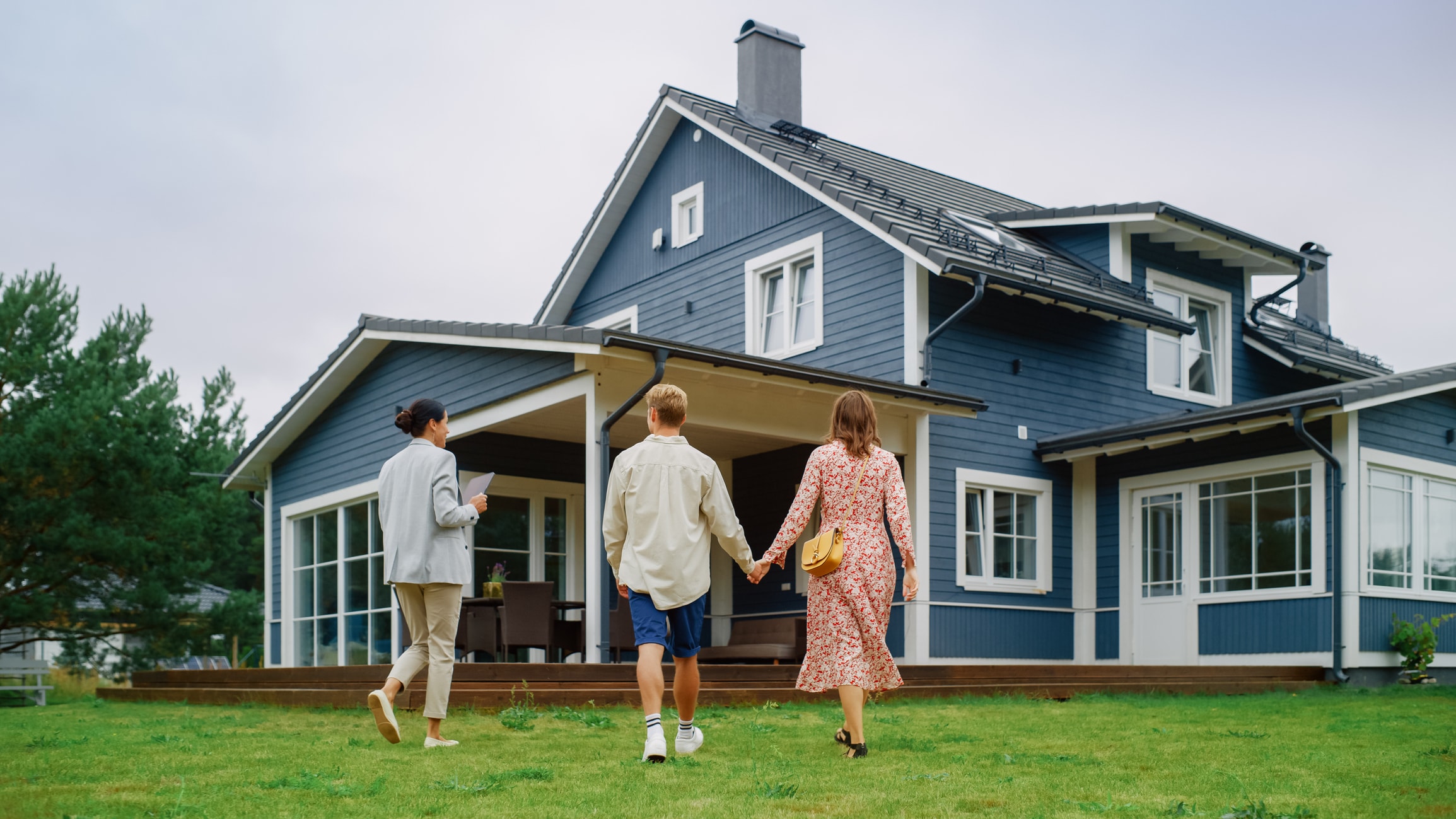 A group of people walking in front of a house