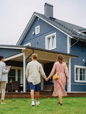 Family outside a home with real estate agent