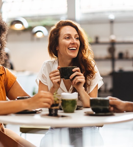 Woman chatting at a table with her friends over coffee
