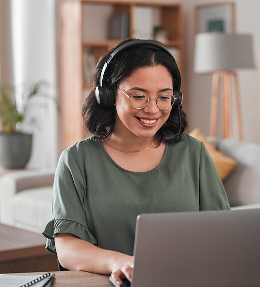 Smiling young woman looking at her laptop to book an appointment