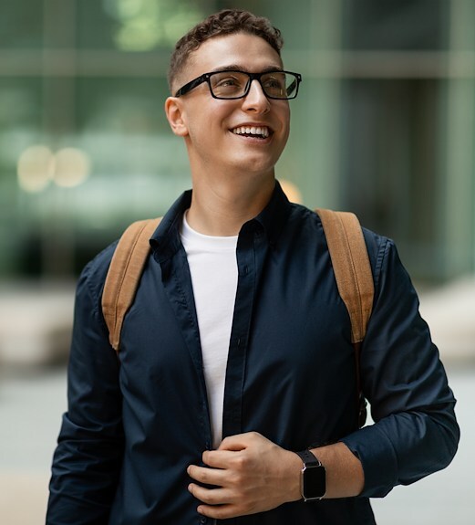 Graduate student walking around camus holding a backpack