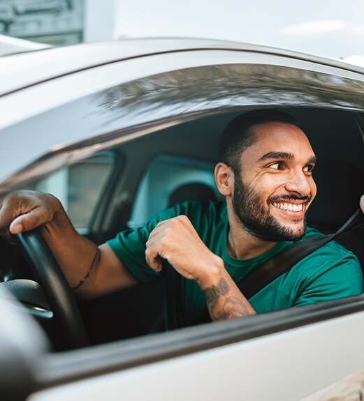 Smiling young man driving a car