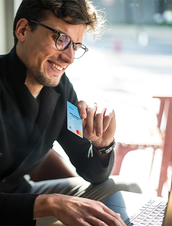 Man holding UCU business credit card making an online purchase