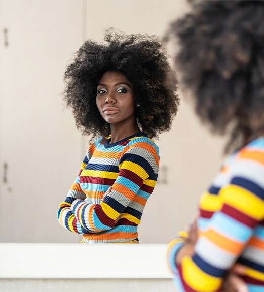 Confident woman looking at her reflection in the mirror