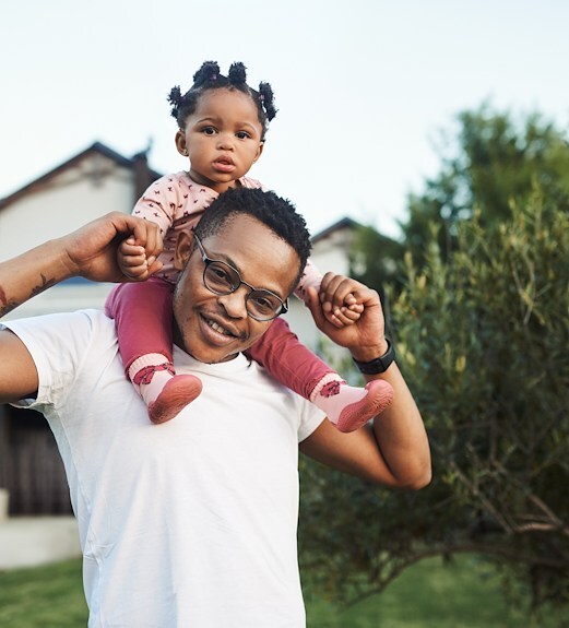 Young happy father holding his daughter on his shoulders