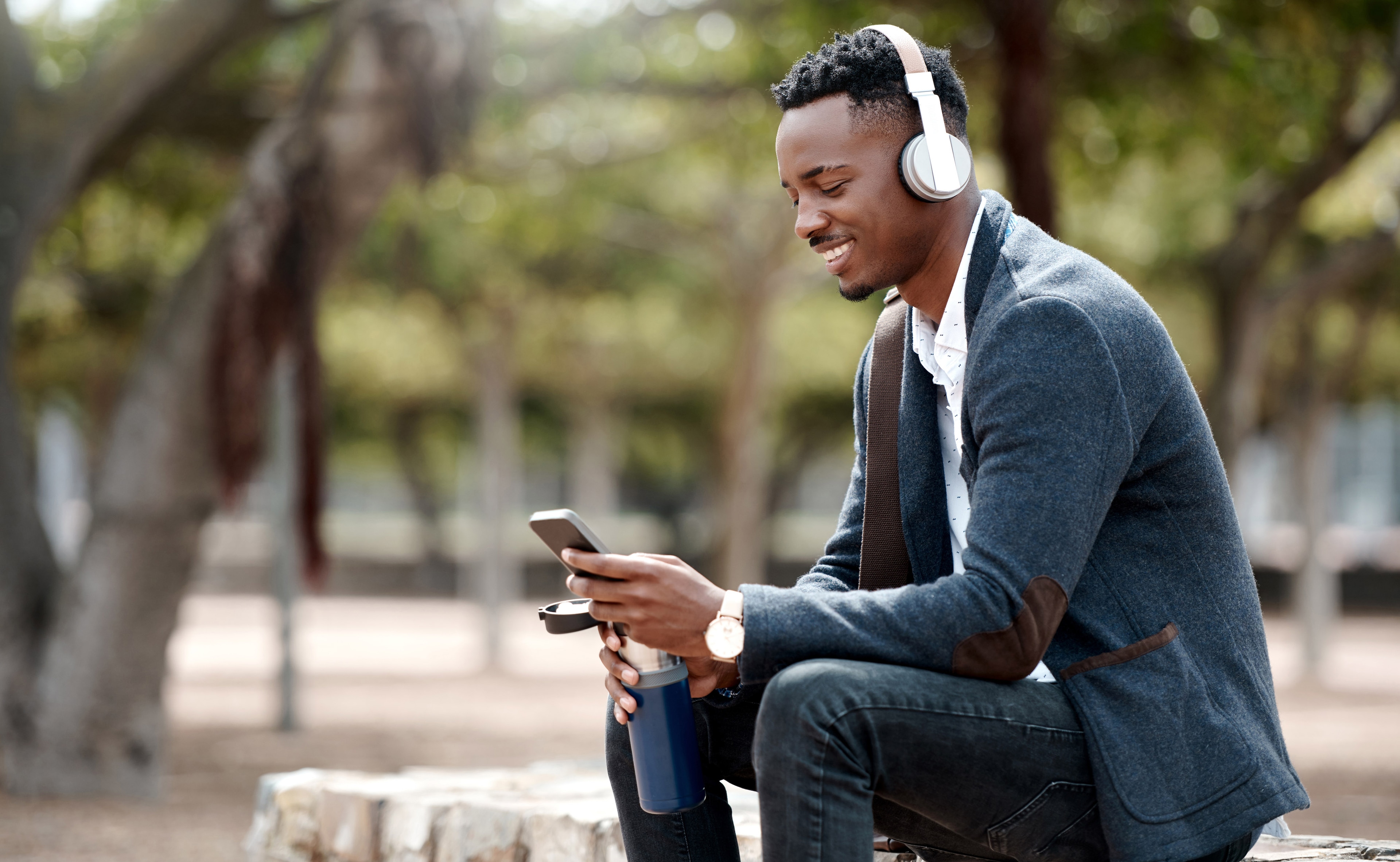 A man sitting on a bench looking at a phone