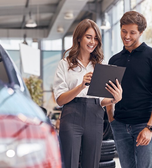 Young woman at a car dealership reviewing vehicle options