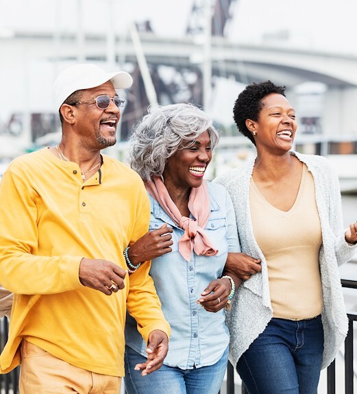 Elderly parents outside walking with their daughter