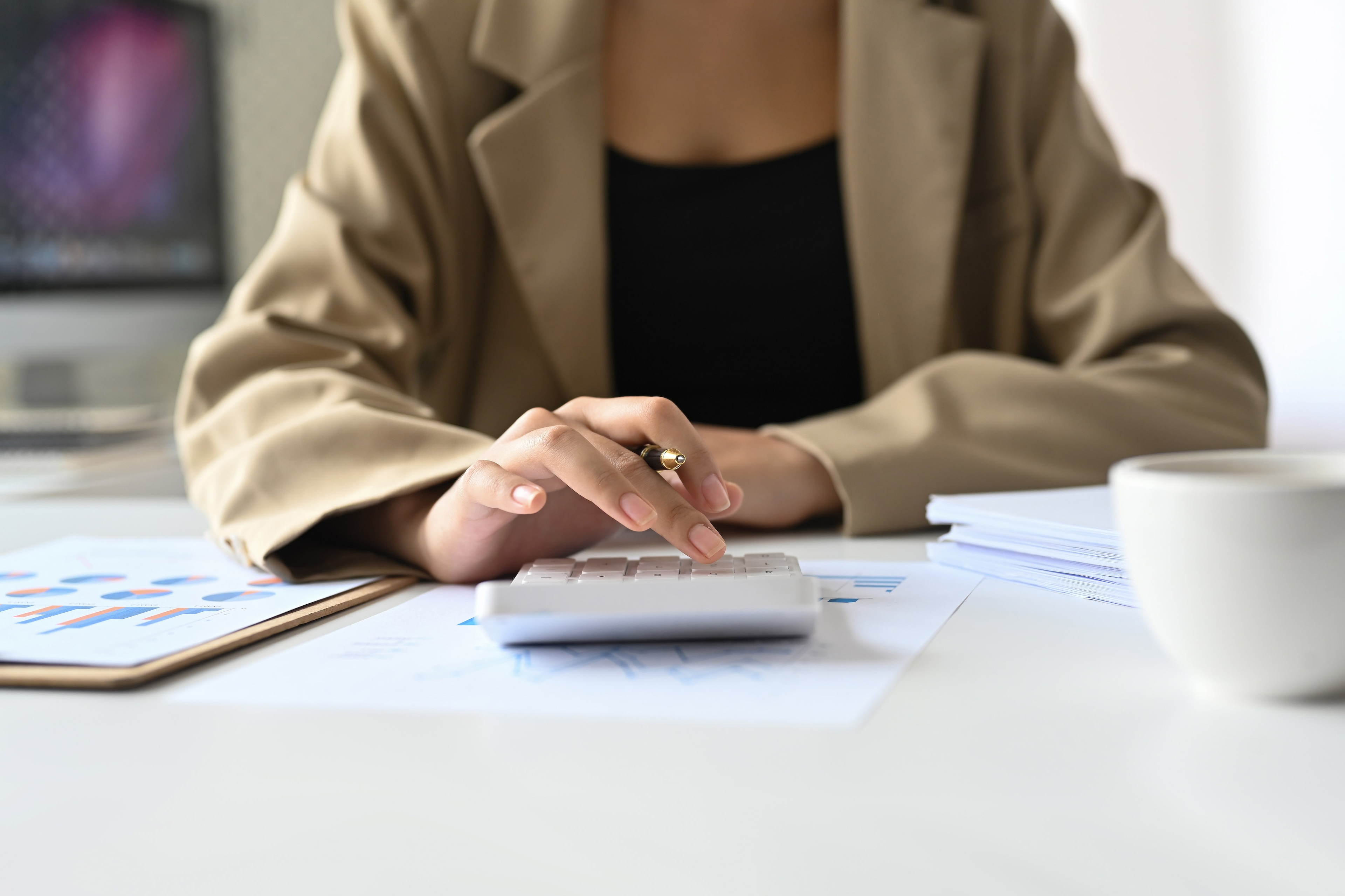 close up view of a person at a desk making calculations