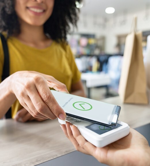 Close up view of a person holding a phone to make a purchase using mobile wallets