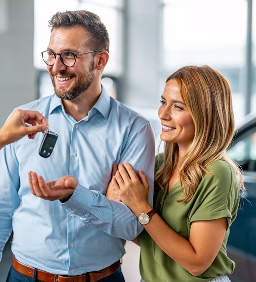 Couple being handed new car keys