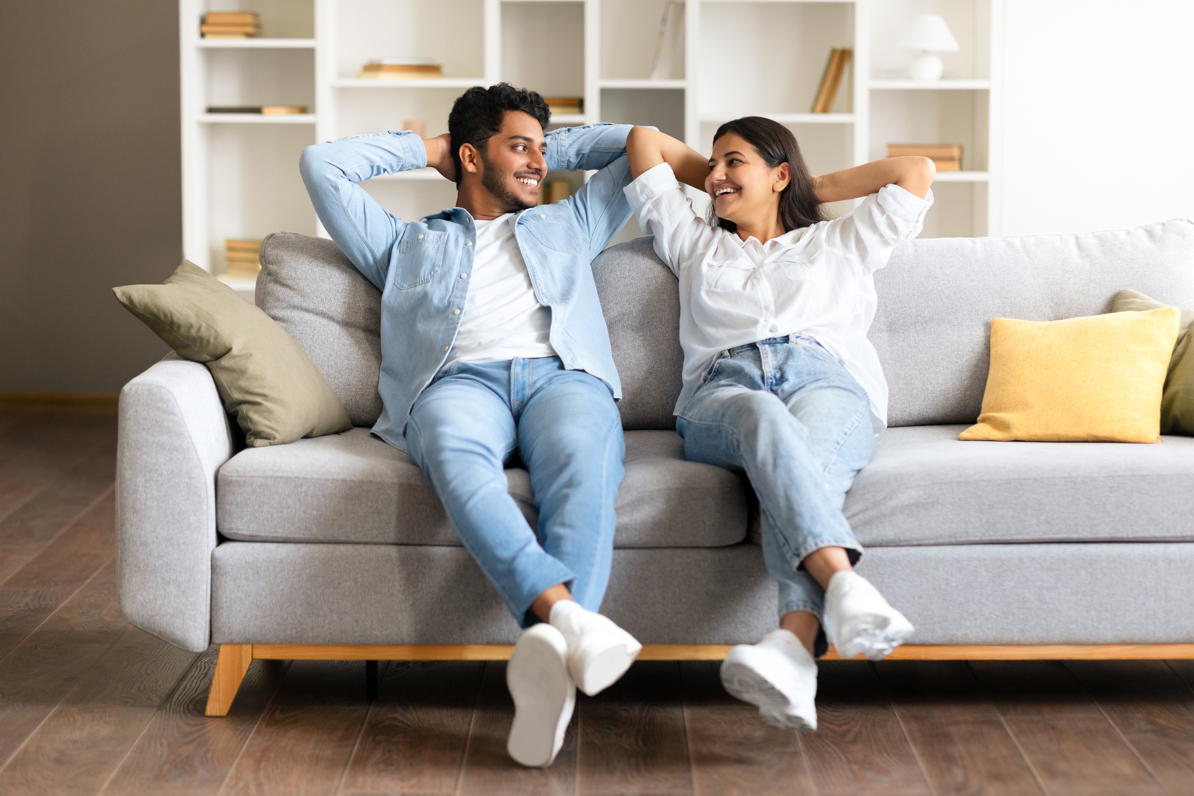 Couple leaning back comfortably on their living room couch