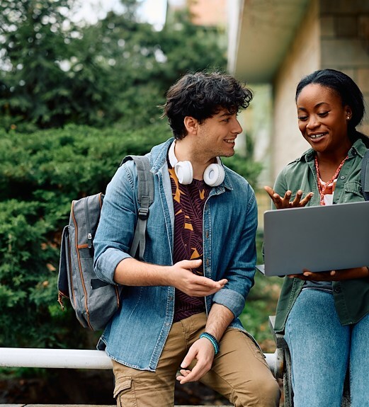 Two college students talking about a project on campus