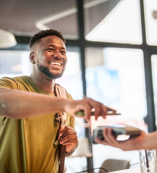 Young man holding out his phone to make a tap payment