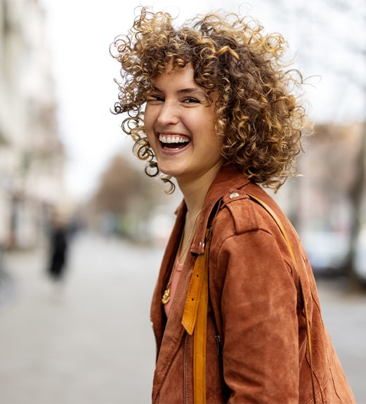 Young woman looking back at the camera laughing