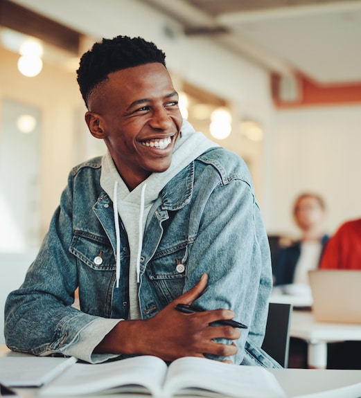 Smiling young college student sitting at a desk